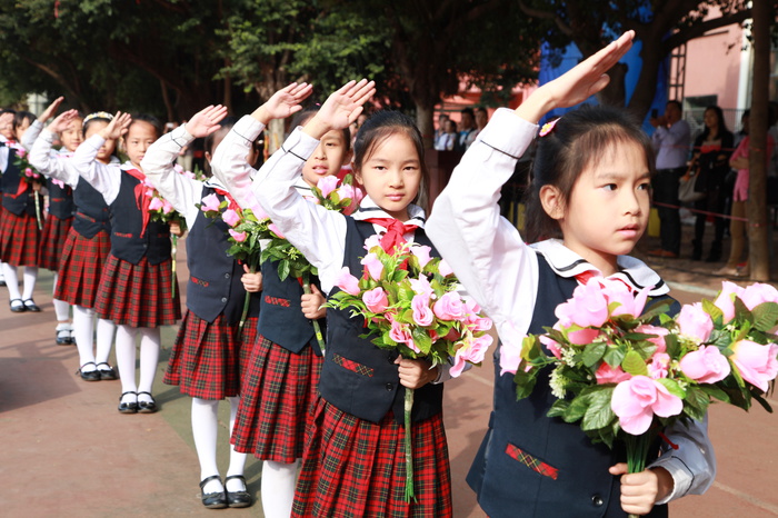 04、图为鲜花队的同学在升国旗仪式时向国旗敬礼